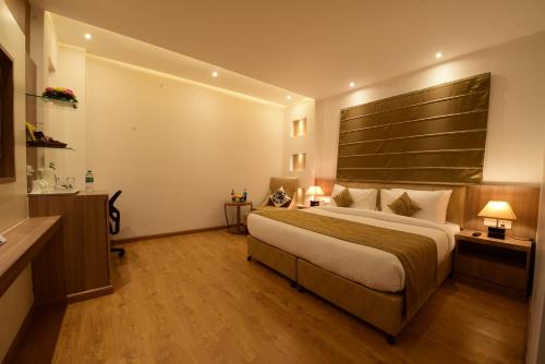 a bedroom with a large bed with a large headboard at SureStay Plus by Best Western Amritsar in Amritsar