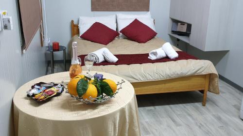 a bed with a table with a bowl of fruit on it at Astrofegia Apartments Near The Sea in Ayia Marina