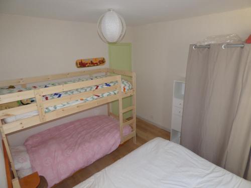 een kleine slaapkamer met een stapelbed en een wieg bij Appartement de la cascade in Eaux-Bonnes