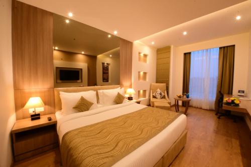 a bedroom with a large bed in a hotel room at SureStay Plus by Best Western Amritsar in Amritsar