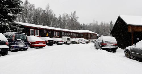 a bunch of cars parked in a snow covered yard at Hotel Waldoase Hirschbüchenkopf in Güntersberge