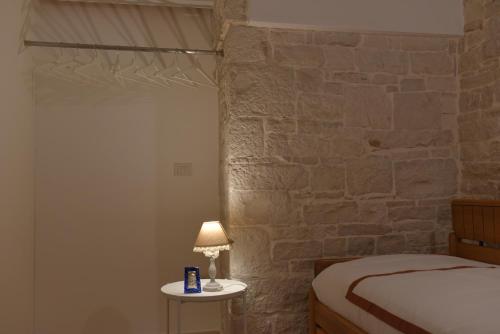 a bedroom with a bed and a lamp on a table at B&B L'alcova in Terlizzi