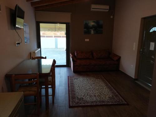 a living room with a table and chairs and a couch at Rea's House Vrachati in Vrahati