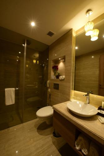 a bathroom with a toilet and a sink and a shower at SureStay Plus by Best Western Amritsar in Amritsar
