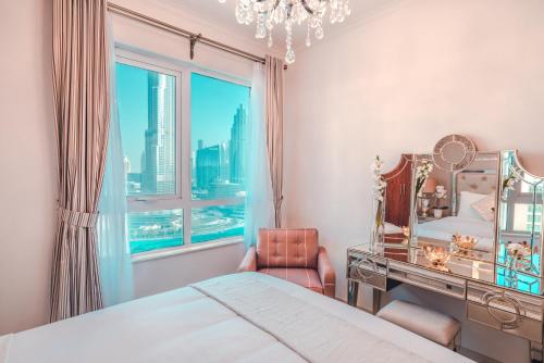 Schlafzimmer mit einem Bett und einem Schreibtisch mit einem Spiegel in der Unterkunft Elite Royal Apartment - Burj Residences T7 - President in Dubai