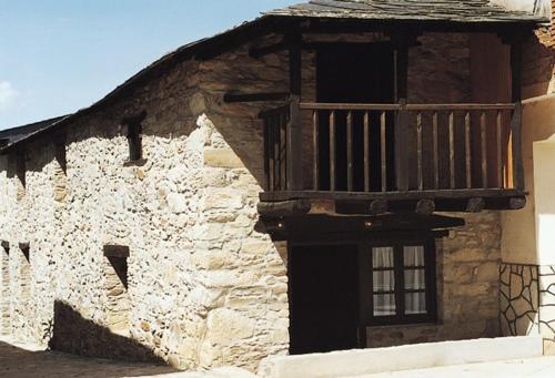 ein altes Steingebäude mit Balkon in der Unterkunft Las Medulas Los Telares in Las Médulas