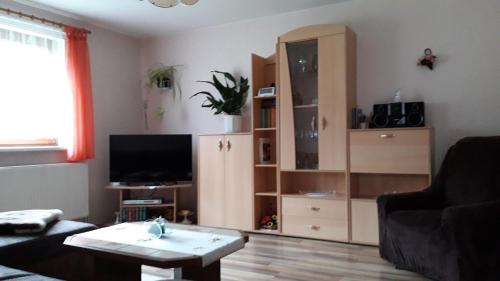 - un salon avec une télévision, un canapé et une table dans l'établissement Ferienhaus Greiling, à Quedlinbourg