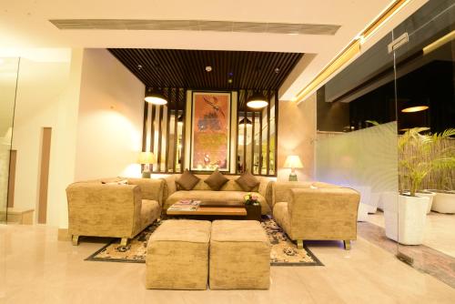 a living room with a couch and two chairs at SureStay Plus by Best Western Amritsar in Amritsar