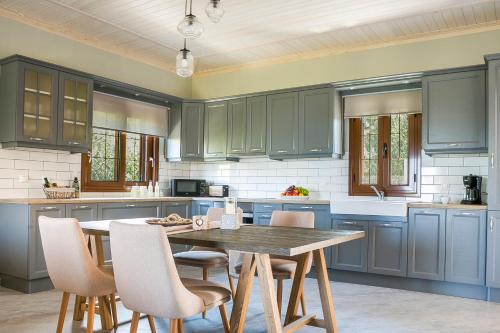 cocina con armarios azules y mesa de madera en Cephalonian Countryside Villa en Divarata