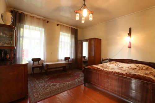 een slaapkamer met een bed, een stoel en een raam bij Guesthouse ''Ashot Shalunts'' in Goris