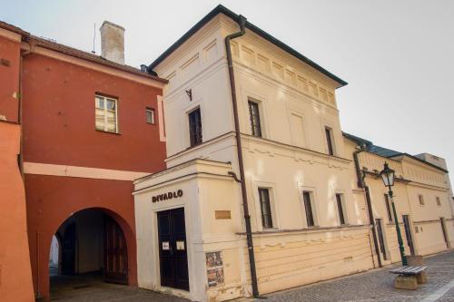 a white building with an archway next to a building at Apartmán U Gotického dvojčete in Litoměřice