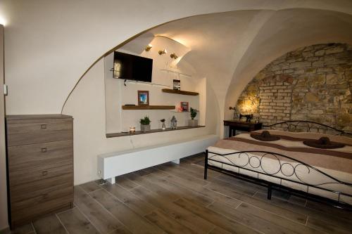 a bedroom with a bed and a stone wall at Apartmán U Gotického dvojčete in Litoměřice