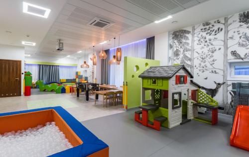 a play room with a toy house and a table at Hotel Krynica Conference & SPA in Krynica Zdrój