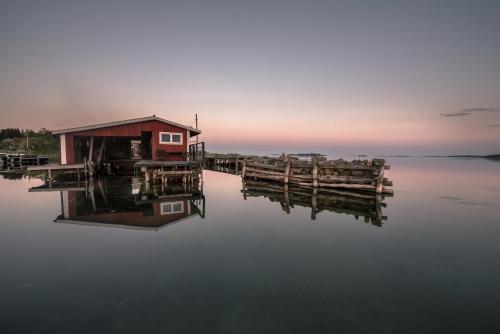 a house on a dock on a body of water at Hasselö Hostel in Hasselö