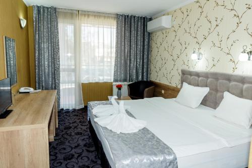 ブルガスにあるFamily Hotel Prestigeのベッドとテレビが備わるホテルルームです。