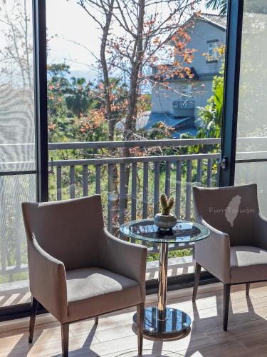 two chairs and a table on a balcony with a view at 宜蘭莫內花園城堡 in Wujie
