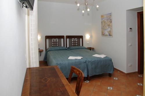 ein Schlafzimmer mit einem Bett und einem Tisch darin in der Unterkunft DolceVitaSorrento Guest House in Sorrent