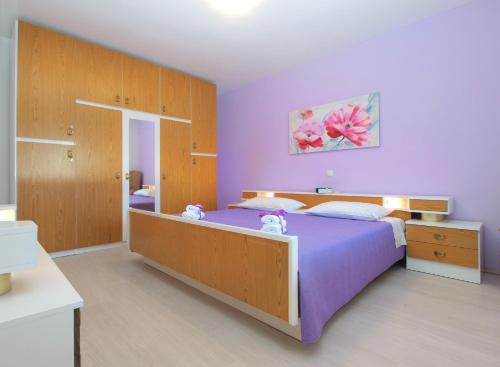 sypialnia z dużym łóżkiem z fioletowymi prześcieradłami w obiekcie Holiday Home Villa Angelina 1233 w mieście Barban