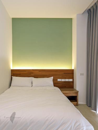 a bedroom with a large bed with a wooden headboard at 宜蘭莫內花園城堡 in Wujie