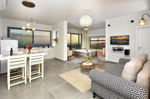 a kitchen and living room with a couch and a table at Nof 10 in Amirim