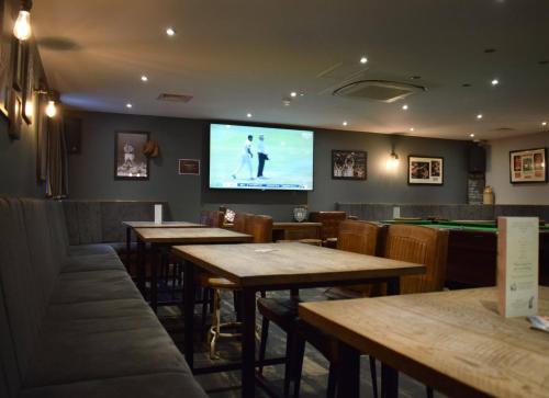 a restaurant with tables and a tv in the wall at The Horse & Jockey in Alfreton