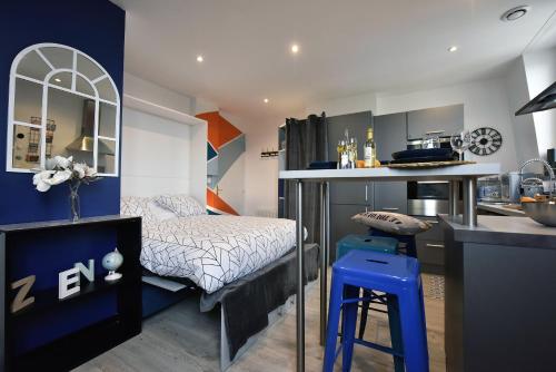 a small bedroom with a bed and a kitchen at Studio L'Échappée Bleue - 250m de la plage in Berck-sur-Mer