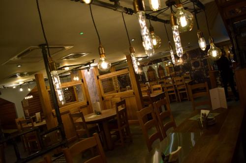 a restaurant with wooden tables and chairs and lights at The Horse & Jockey in Alfreton