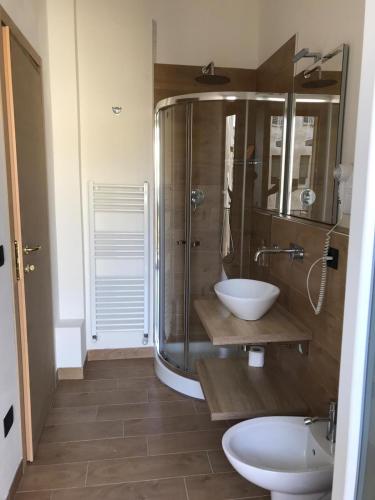 a bathroom with a glass shower and two sinks at Riva Reno 4 Rooms in Bologna