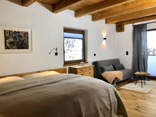 um quarto com uma cama, um sofá e uma janela em Apartments Angela em Fieberbrunn