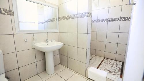 a bathroom with a sink and a mirror at Jock-Sabie Lodge in Sabie