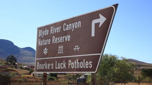 a brown sign with an arrow on a road at Jock-Sabie Lodge in Sabie
