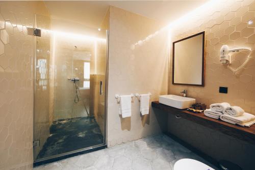 a bathroom with a shower and a sink and a mirror at Málaga Premium Hotel in Málaga