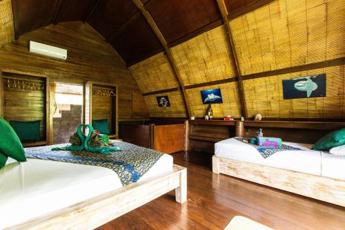 Aura Villa & Spa Amed Bali tesisinde bir odada yatak veya yataklar