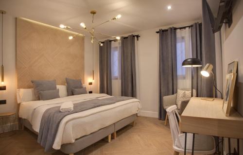 a bedroom with a large bed and a desk at Suites You Soho in Madrid