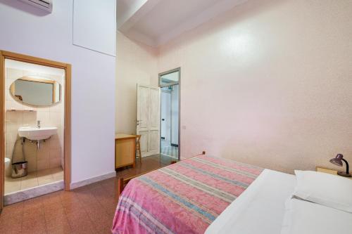a bedroom with a bed and a sink and a mirror at B&B Castiglia in Palermo