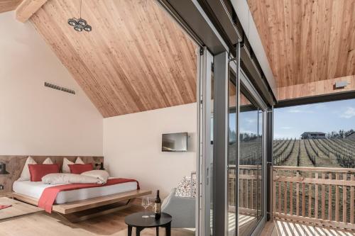 sypialnia z łóżkiem i balkonem w obiekcie Winzerhäuser J&A Skringer w mieście Leutschach