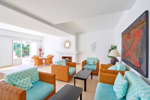a living room with couches and chairs and a fireplace at Gavimar Cala Gran Hotel and Apartments in Cala d´Or