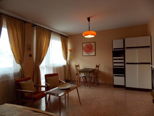 a living room with a table and chairs at Heviz Therme Apartmenthaus in Hévíz