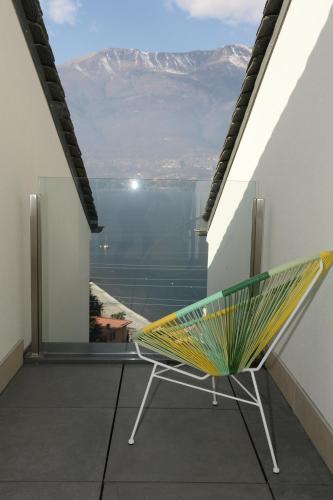 a chair on a balcony with a view of a mountain at Casa MICHI in Dervio
