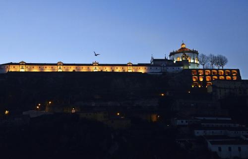 a building on top of a hill at night at RVA - Gustave Eiffel Apartments in Porto