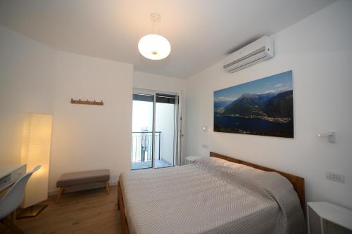 a bedroom with a bed and a large window at Casa MICHI in Dervio