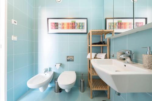 uma casa de banho com um lavatório branco e um WC. em Fontaínhas Stylish Apartment by DA'HOME no Porto