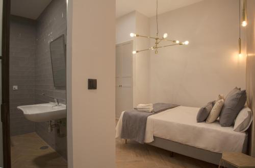 a bedroom with a bed and a sink and a mirror at Suites You Soho in Madrid