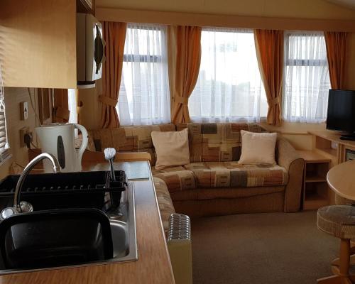 a kitchen and living room with a couch and a sink at 4 Berth with private Garden - 58 Brightholme Holiday Park Brean! in Brean