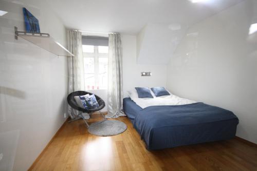 um quarto com uma cama, uma cadeira e uma janela em Penthouse with perfect location and spectacular view em Bergen