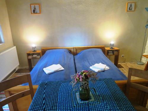 Un dormitorio con una cama azul y una mesa con flores. en Medieval Apartments Frauendorf, en Axente Sever