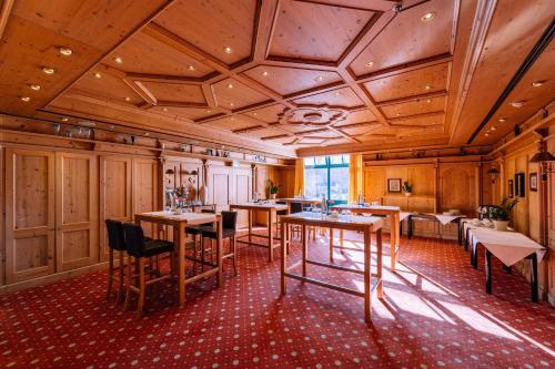 a restaurant with wooden ceilings and tables and chairs at Atomis Hotel Munich Airport by Mercure in Oberding