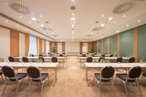 a large conference room with tables and chairs at Atomis Hotel Munich Airport by Mercure in Oberding