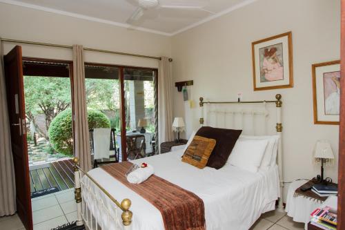 a bedroom with a bed and a balcony at Rustic Butler B&B in White River