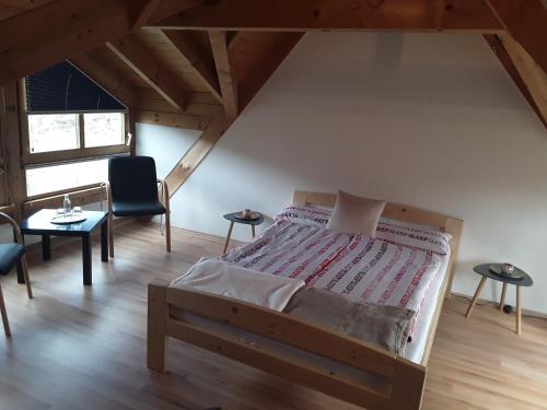 ein Schlafzimmer mit einem Bett und einem Stuhl im Dachgeschoss in der Unterkunft Apartment da Graziella in Bad Kreuznach